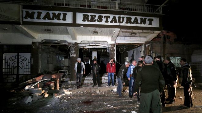 Residents inspect damage from a suicide bomb in Qamishli, Syria December 30, 2015.