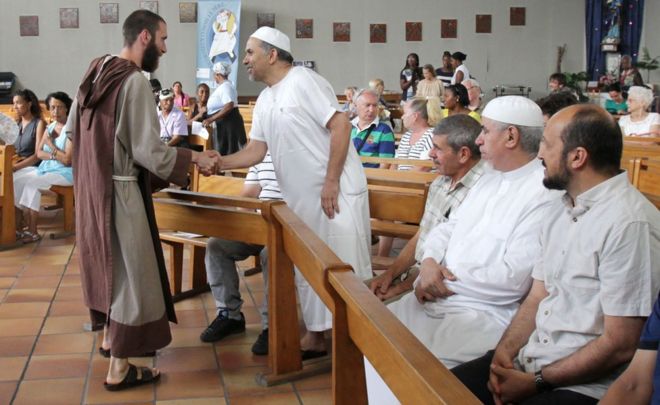 A catholic monk welcomes muslim worshippers in the Saint-Pierre-de-lAriane church, prior to a mass on July 31, 2016, in Nice, southeastern France