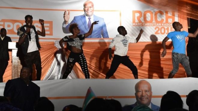 Artists perform before a banner of Burkina Faso's new president Roch Marc Christian Kabore in Ouagadougou on 1 December 2015