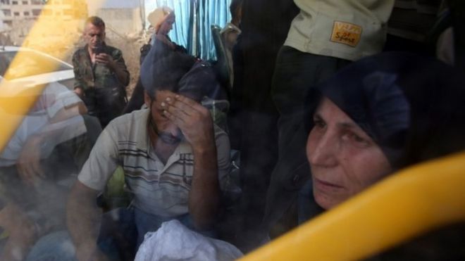 Residents leave Daraya on a bus