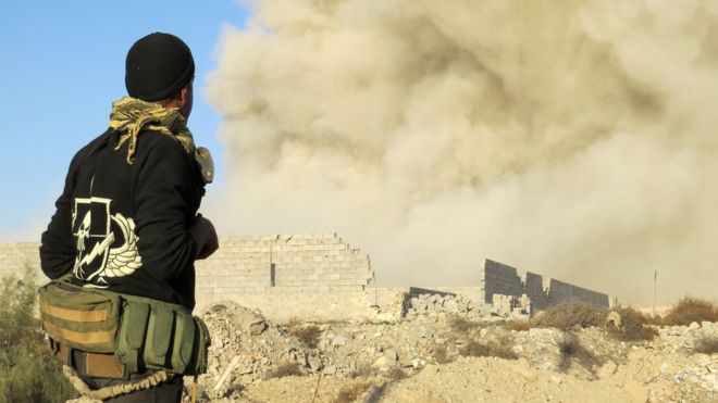 Iraqi pro-government soldier watches smoke billowing from Ramadi's Hoz neighbourhood on 27 December 2015