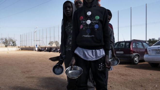 Migrants queue up for food at a detention centre in Libya