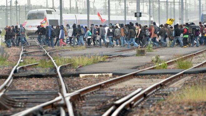 People cross railway lines during a protest against labour law reforms in Rennes, on May 26, 2016