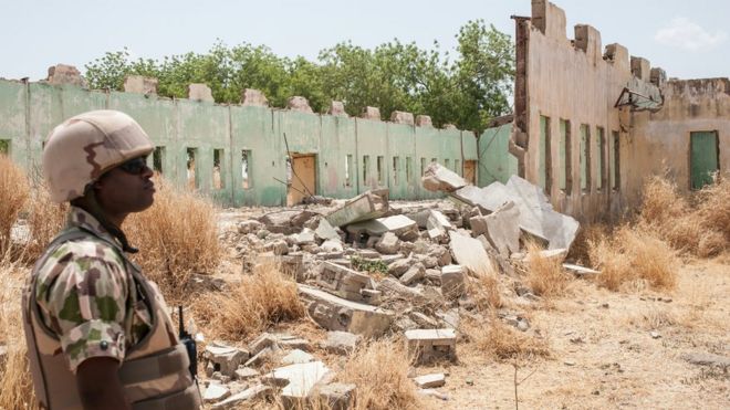 A soldiers stands next to a school destroyed by Boko Haram in Borno State, Nigeria