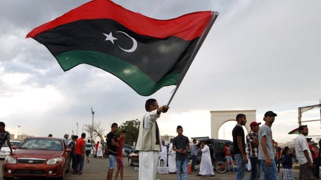 A Libyan man waves his national flag during a demonstration against supporters of the regime of former dictator Muammar Gaddafi in Benghazi