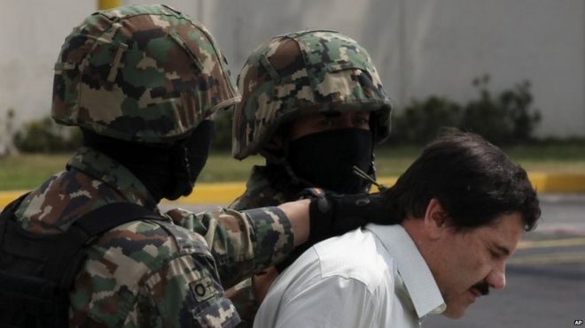 In this 22 February file photo Joaquin "El Chapo" Guzman is escorted to a helicopter by Mexican navy marines