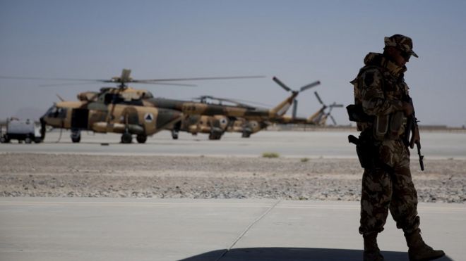A Nato soldier stands guard under the wing of a C-130 Hercules aircraft that belongs to the Afghan National Army, in Kandahar Air Field, Afghanistan, Tuesday, Aug. 18, 2015
