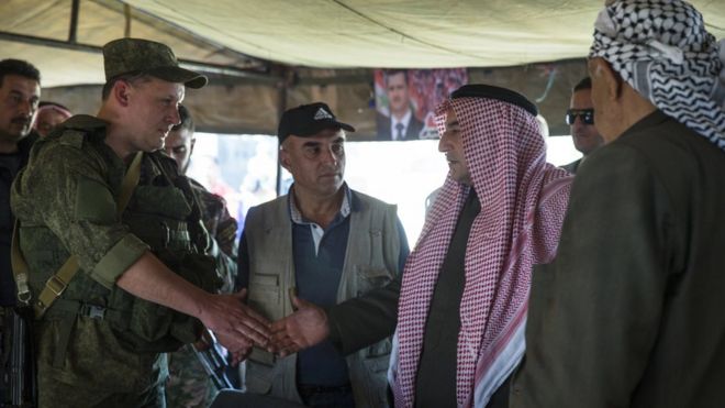 Sheikh Ahmad Mubarak, second from right, shakes hands with a Russian military officer after signing a cease-fire declaration in Maarzaf, about 15 kilometres west of Hama, Syria, Wednesday, March 2, 2016