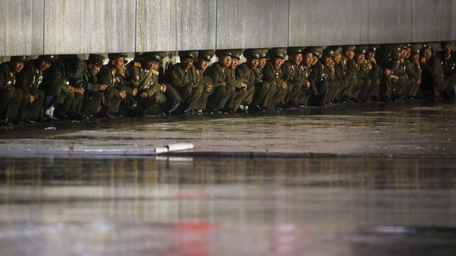 Soldiers sheltering from the rain after the military parade for the 70th anniversary of the founding Workers' Party, Pyongyang, North Korea - Saturday 10 October 2015