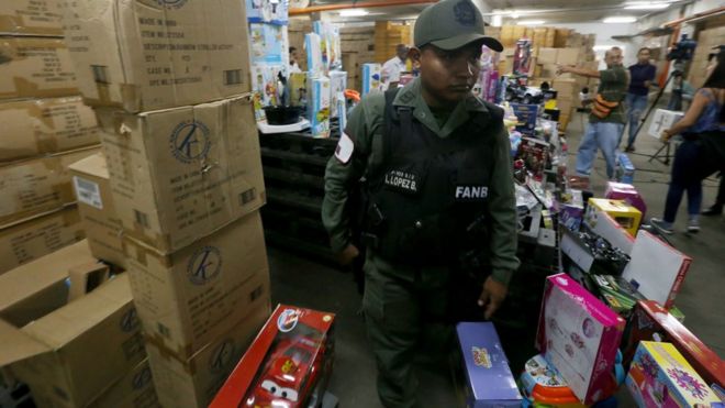 A handout photo released by Venezuelan News Agency (AVN) shows a member of Venezuelan Armed Forces walking among boxes of toys during an operation at a toy store in Caracas, Venezuela, 09 December 2016.