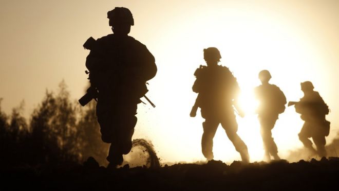 A silhouette of US soldiers in action in Afghanistan