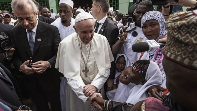 Pope Francis (C) shakes the hands of children upon his arrival to the Central Mosque in the PK5 neighborhood on November 30, 2015 in Bangui