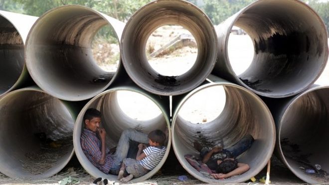 Indians rest in unused water pipes to avoid the heat on a hot summer day in New Delhi, India, 19 May 2016