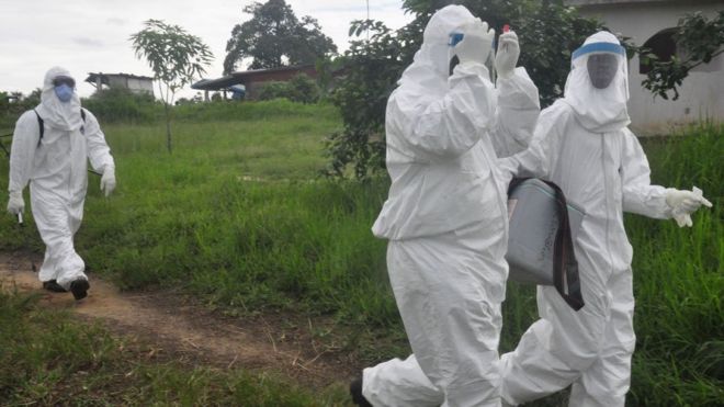 Health workers leave after they took a blood specimen from a child to test for the Ebola virus in a area were a 17-year old boy died from the virus on the outskirts of Monrovia, Liberia, Tuesday, June 30, 2015