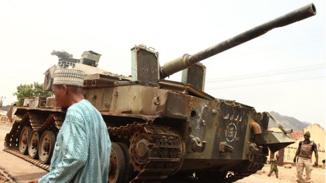 A man walks by a tank left by Boko Haram militants 10 2015.