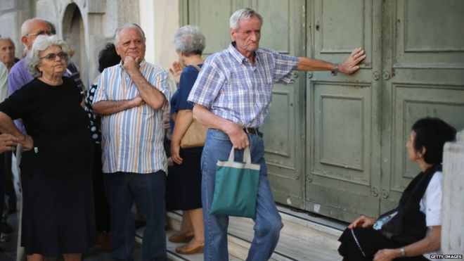 Senior citizens queue up to collect their pensions outside a National Bank of Greece branch in Kotzia Square in Athens, Greece, on Tuesday