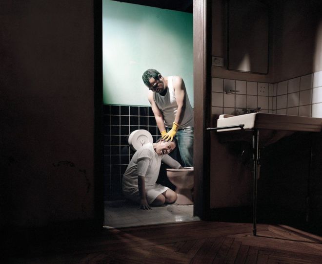 رجل يجبر امرأة على وضع يدها في مرحاض