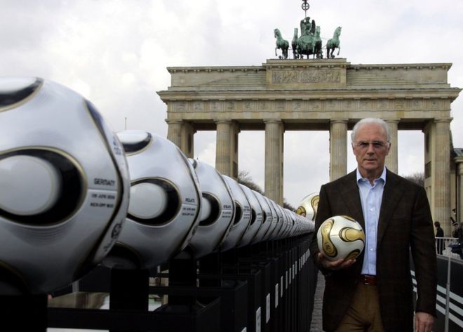 Franz Beckenbauer, president of Germany's World Cup organising committee, holds a golden soccer ball during a presentation next to the Brandenburg Gate in Berlin, 18 April 2006