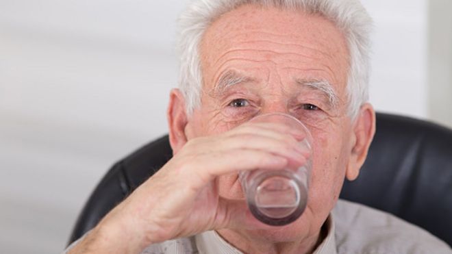 Elderly man drinking water
