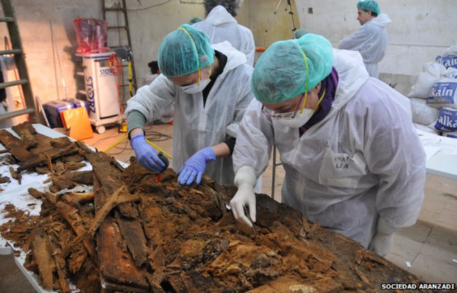 Experts examine the remains of coffins at a table inside the crypt of Madrid's Trinitarian convent in this handout picture released by Madrid's City Hall January 26, 2015
