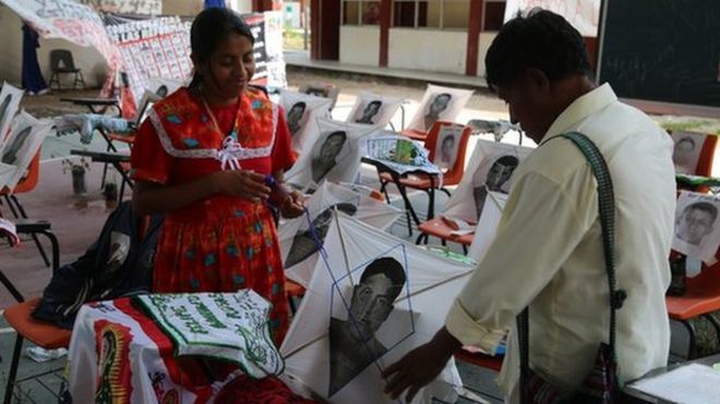 Woman and man look at photos of missing students