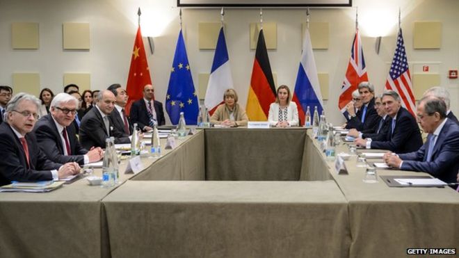 Representatives of six world powers sit around a table