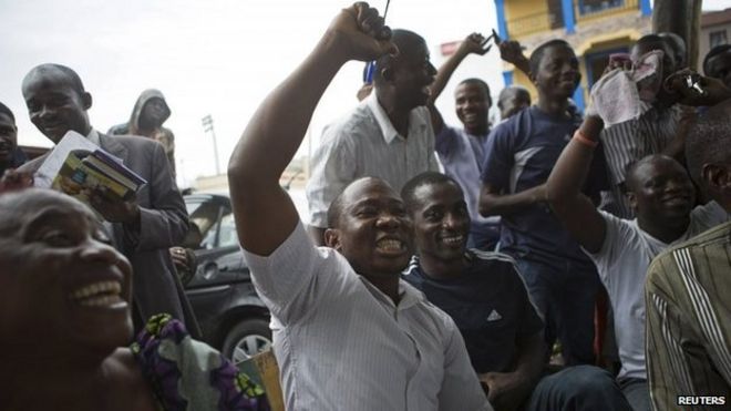 Supporters of presidential candidate Muhammadu Buhari cheer as they watch news coverage of election results favourable to them on a street in Lagos, 31 March 2015