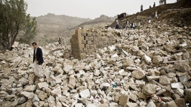 Yemenis stand amid the rubble of houses destroyed by Saudi-led airstrikes in a village near Sanaa, Yemen, 4 April 2015