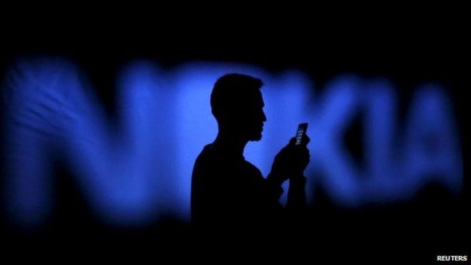 A man silhouetted against a Nokia logo