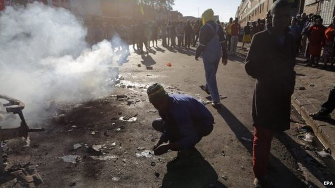 Smoke rises from a burning vehicle after another night of xenophobia-related violence in Johannesburg, South Africa, 17 April 2015