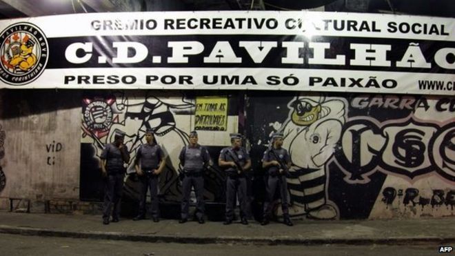 Policemen stand guard outside the Corinthians fans "Hall 9" headquarters after the shooting