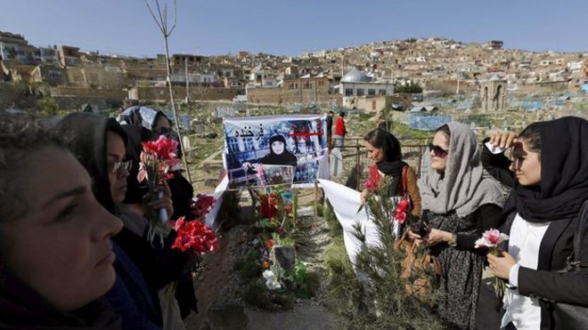Afghan women's rights activists hold flowers at the grave of Farkhunda who was lynched by a crowd of men in central Kabul on March 26, 2015.