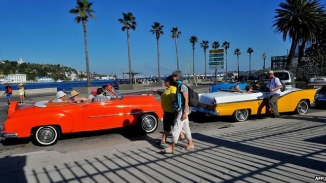 Tourists from the United States are seen in old American cars in Havana on 6 April, 2015.