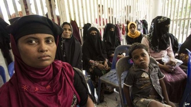 Migrant women and children from Myanmar and Bangladesh wait at a shelter after being rescued off Indonesian on 10 May