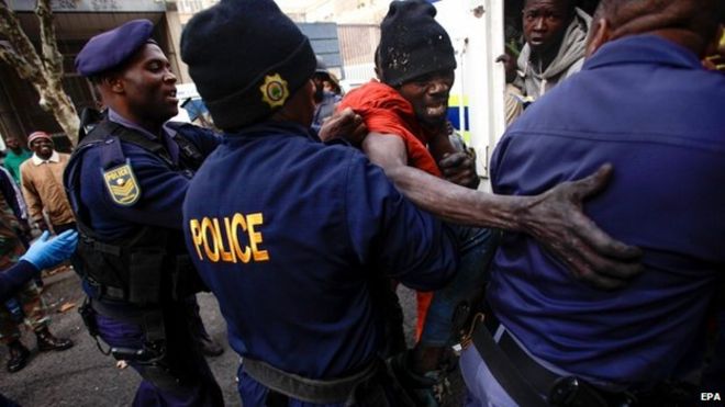 Members of the South African Police detain a foreign national in downtown Johannesburg, South Africa, 08 May