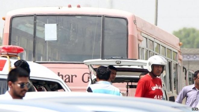 Rescue workers stand beside the bus