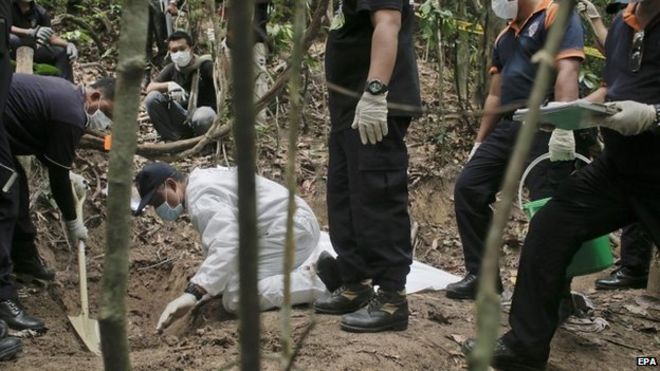 A forensics team digs at a grave found at Wang Burma hills at Wang Kelian, Perlis, Malaysia - 26 May 2015