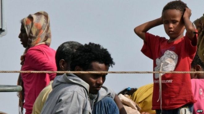 Migrants disembark from an Italian military ship as they arrive in the port of Augusta, on the eastern coast of Sicily (21 May 2015)