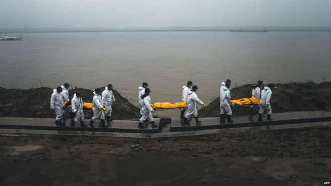 People carry the bodies of the victims of the capsized Chinese cruise ship