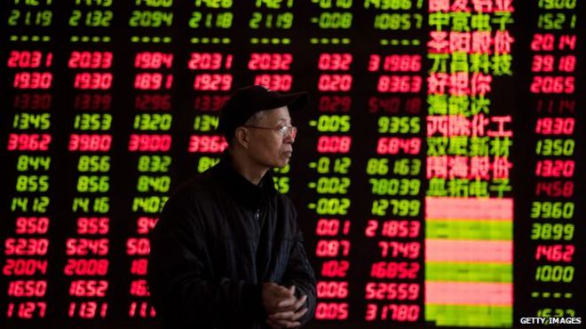 A man standing by a stock board