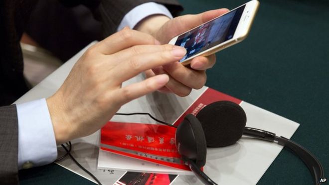A Chinese Communist party cadre checks his mobile phone