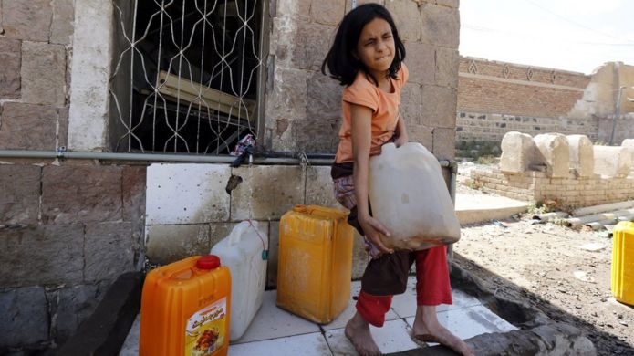 A Yemeni girl tries to carry a jerrycan full of clean water at a donated source amid ongoing widespread disruption of water supplies