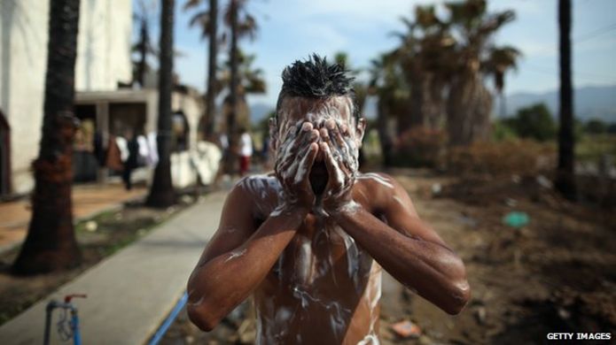 Migrant washes himself in Kos, Greece, on 4 June 2015