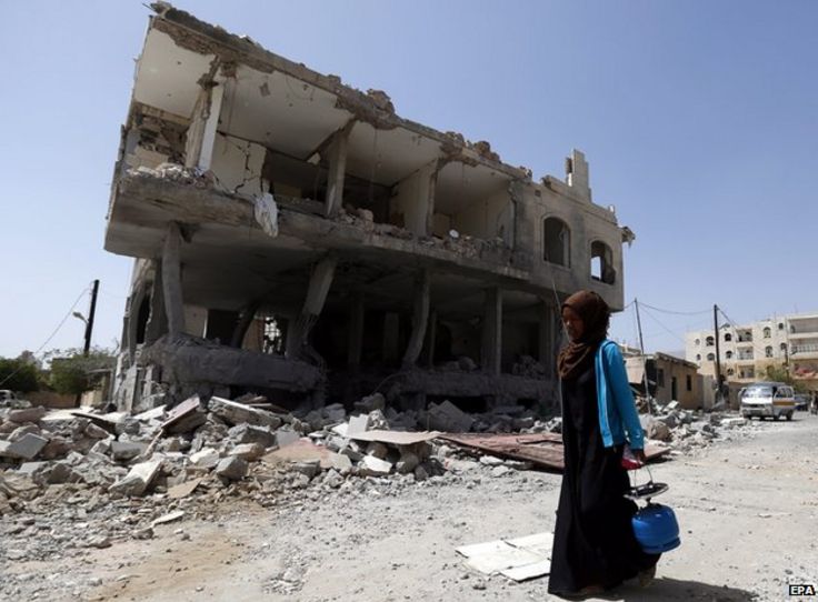 A woman passes a building allegedly destroyed by an airstrike carried out by the Saudi-led coalition in Sanaa, Yemen, 27 April 2015