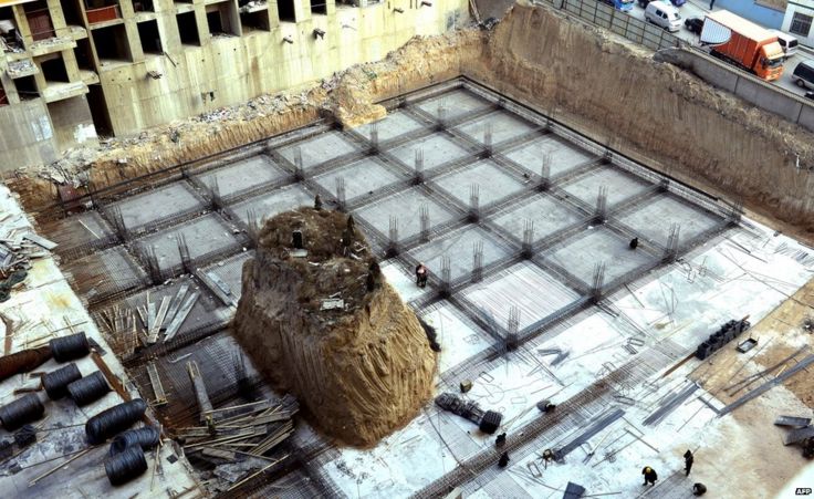 Chinese workers building around a grave mound 10 meters high, at a construction site in a village in Taiyuan, north China's Shanxi province