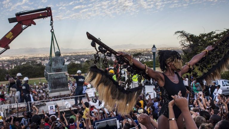 Students cheer as the Cecil Rhodes statue is being removed from the University of Cape Town in South Africa on 9 April 2015