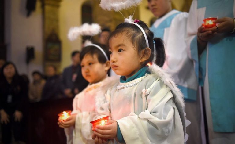 Young Chinese worshippers attend the Christmas Eve mass at a Catholic church in Beijing on December 24, 2015