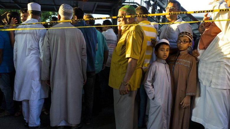 Muslim community gather near the site of the shootng