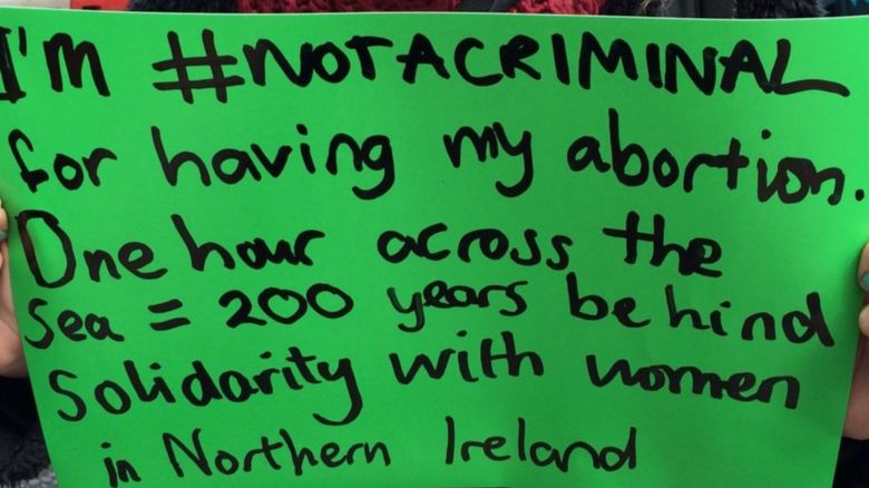 Placard reading: %22I'm #notacriminal for having my abortion. One hour across the sea = 200 years behind. Solidarity with women in Northern Ireland.%22