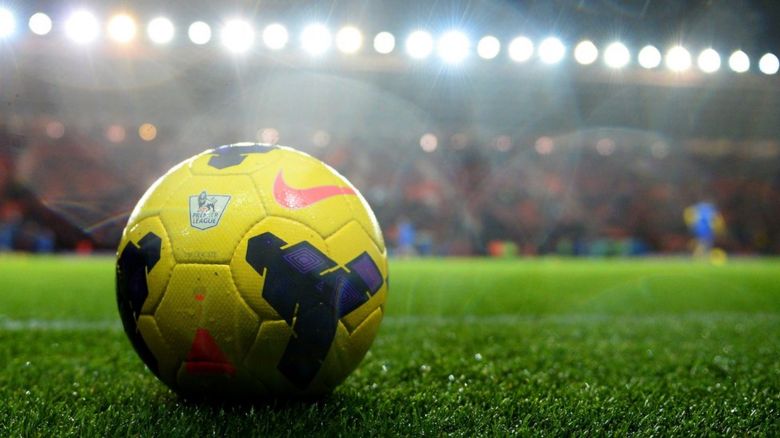 Football on pitch in stadium.
